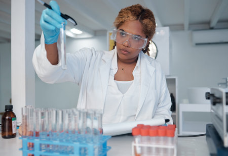Searching for the next best thing. a young female lab worker filling test tubes with liquid.