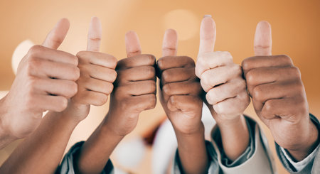 Show your thumbs up. a group of unrecognizable businesspeople showing a thumbs up at work.
