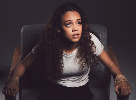 Hold yourself back, or heal yourself back together. a young woman tied to a chair against a black...
