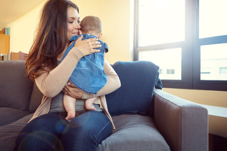 Mom, bonding and baby girl hug in house living room or family home sofa in support trust, love and...