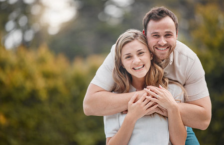 Happy young caucasian couple bonding at the park or garden outside in nature. Affectionate husband...