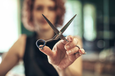 Time for the big chop. an unrecognisable hairdresser standing and holding a pair of shears in her salon.の写真素材