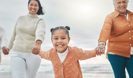 Come on guys. an adorable little girl pulling her mother and grandmother along the beach.