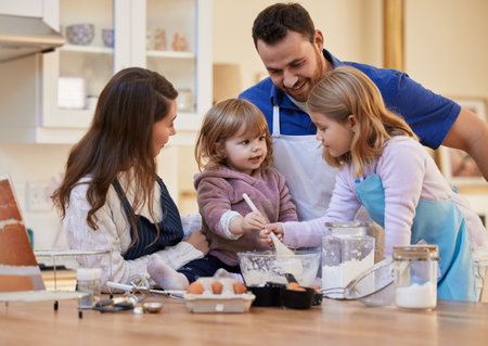 You both can take turns. a family baking together while a little girl stirs a bowl of cake batter.