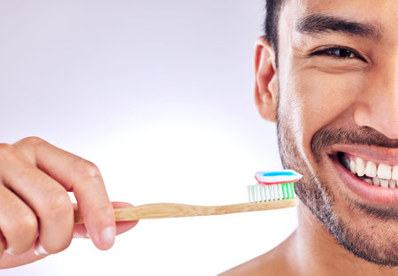 Stick to a daily routine of brushing and flossing. Studio shot of a handsome young man holding up...