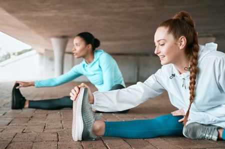 A great workout requires no equipment. two friends stretching before a run.の写真素材