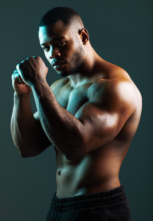If you take me on, expect to lose. a handsome young man boxing against a studio background.の写真素材