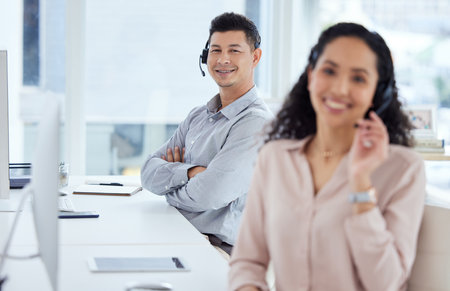 Making big sales is an easy thing for us. Portrait of a young call centre agent working in an office with his colleague in the foreground.の写真素材