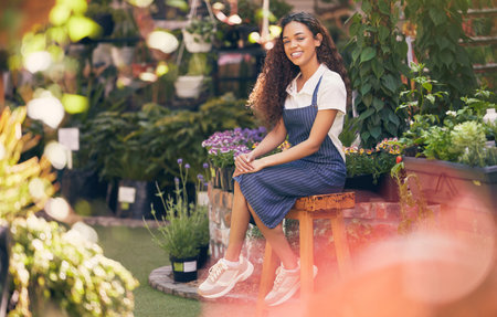 A rose among the thorns. a beautiful young florist sitting in her garden.の写真素材