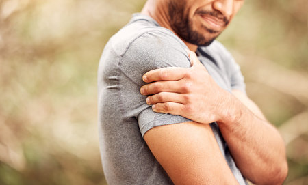 I should have spent more time on my warmup. an unrecognisable man experiencing shoulder pain while...