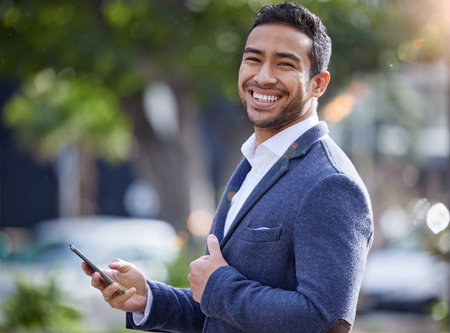 Staying in the know. a young businessman using his smartphone to send a text.の写真素材