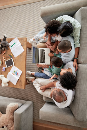 Family, children and video call with kids, parents and grandparents using a laptop on the sofa at home. Communication, wave and internet with a girl, boy and relatives in a living room from aboveの写真素材
