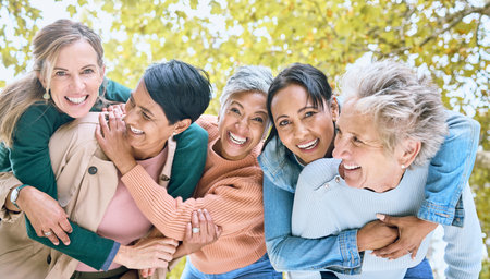 Friends, park and portrait of group of women enjoying bonding, quality time and relax in retirement together. Diversity, friendship and faces of happy senior females with smile, hugging and laughの写真素材