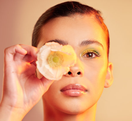 .Beauty, makeup and portrait of woman with flower for luxury cosmetics, skincare products and fashion. Neon studio, creative art and face of girl with plant for self care, glamour and satisfaction.の写真素材