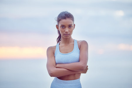 Progress is about being consistent. a young woman getting ready for a jog outdoors.の写真素材