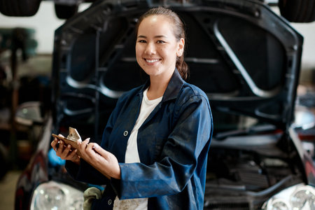 Rely on the best in the business for assistance. a female mechanic holding a clipboard while working...