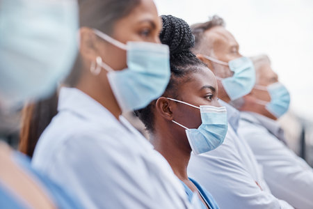 Hospital workers are heroes. Closeup shot of a group of doctors wearing masks.の写真素材