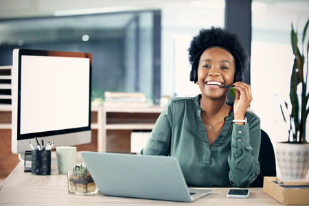 The friendliest agent by far. Portrait of a young businesswoman wearing a headset while working on a...