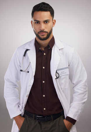 What do you mean you didnt wear your mask. a handsome young doctor standing alone in the studio.の写真素材