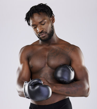 Fitness, boxing gloves and black man fight for sports training and workout in studio with strong muscle. Athlete boxer person ready for exercise, performance and mma competition with power and energyの写真素材
