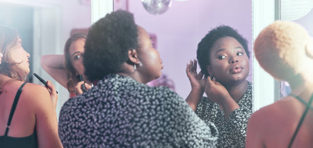 Black woman, night out and girls in bathroom, ready for party and evening out for dancing, bonding and fun. Ladies, females and friends fixing hair, makeup and outfit for club, beauty and happinessの写真素材