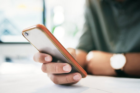 Having a phone is both a good and bad thing. an unrecognizable businessperson using a cellphone in...