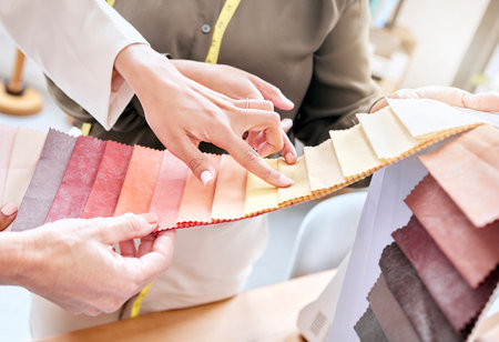 Fashion, hands and women with fabric choice for color in workshop. Teamwork, collaboration and planning of female designers or tailors choosing textile, swatch or colors for clothing in boutique.の写真素材