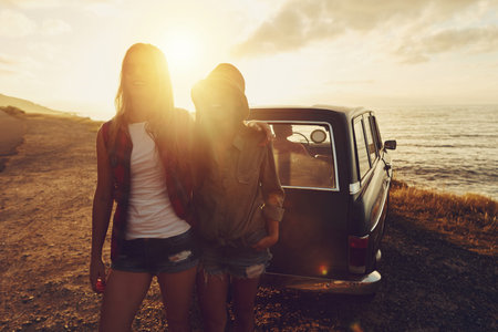 Sunset lens flare with women, car and road trip, travel with friends at beach, outdoor with nature...