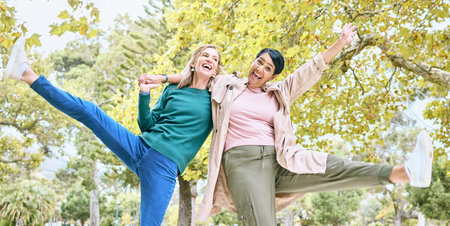 Dance, happy or senior friends in a park in celebration of a crazy, funny or relaxing holiday vacation in summer. Wellness, old woman or elderly women hugging, bonding or dancing playfuly in natureの写真素材