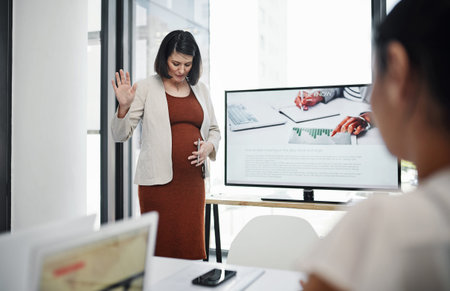 Babys putting the kick in kickoff meeting. a pregnant young businesswoman delivering a presentation to her team in a modern office.の写真素材
