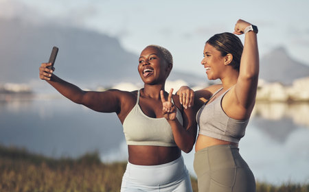 We in on the bestie fitness challenge. two women taking a selfie while out for a run.together.の写真素材