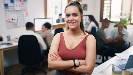 Dont strive to be better, strive to be the best. Portrait of a confident young businesswoman working in a modern office with her team in the background.の写真素材