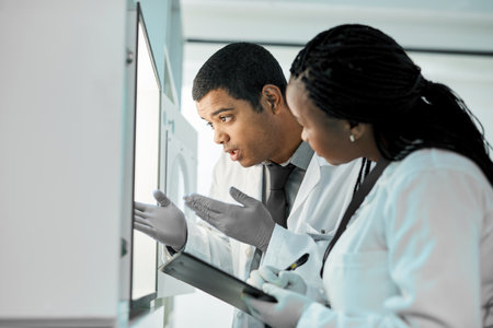 Putting all their data together. two scientists working together in a lab.の写真素材