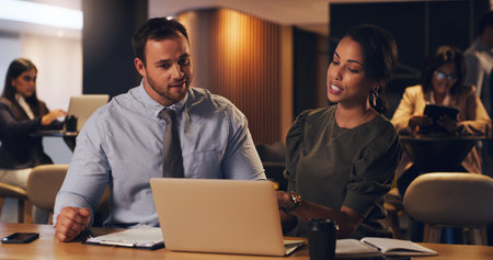 Working through all their plans in detail. two businesspeople working together on a laptop in an...