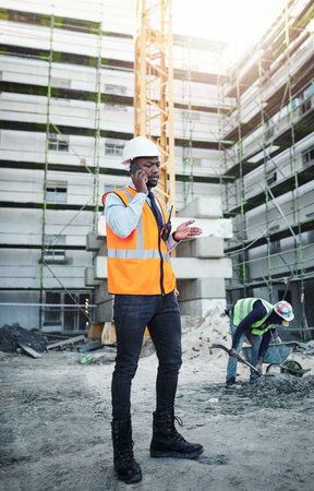 Team members are never too far with wireless technology. a young man using a smartphone while working at a construction site.の写真素材