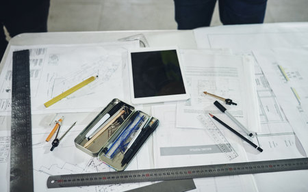Lets get building. various tools and a blueprint on a table at a construction site.の写真素材