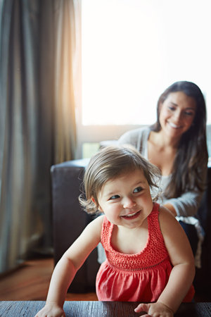Cute, happy and baby playing with mother, bonding and relaxing in the living room of a house. Relax,...