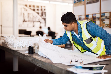 No one plans better than him. a young architect looking at a blueprint in his office.の写真素材