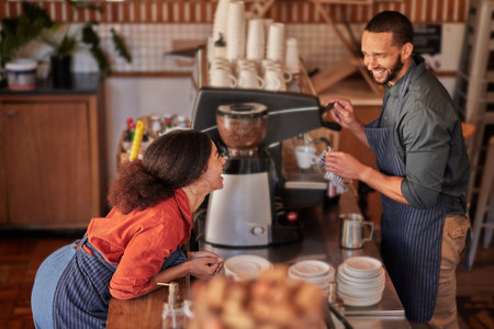 Coffee, cafe and barista couple laughing at funny meme, joke or comedy. Small business owners, waiters and diversity of happy man and woman working in restaurant while talking or comic conversation.の写真素材