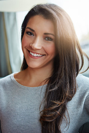 Beautiful woman, portrait smile and brunette relaxing at home with long hair in casual wear and...