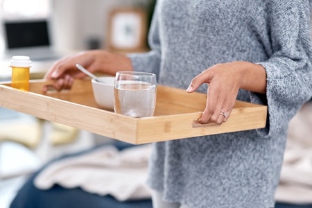 A healthy homemade breakfast for the patient. an unrecognisable woman serving breakfast in bed while to someone recovering from an illness at home.の写真素材
