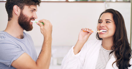 Who said routine has to be boring. a happy young couple brushing their teeth together at home.の写真素材