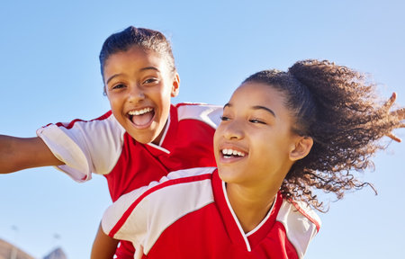 Sports soccer portrait, blue sky and happy kids excited for winning goal, competition success or fun challenge achievement. Winner, celebration and team friends, children or football player piggybackの写真素材