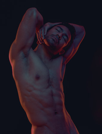 Nude, skin and freedom with a model asian man in studio on a dark background for artistic body positivity. Art, natural and artwork with a handsome young male posing naked on a black backdropの写真素材