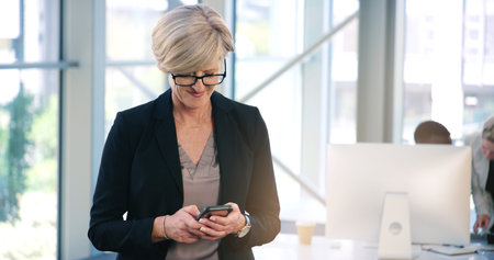 Stay connected so you can stay ahead. a mature businesswoman texting on a cellphone in an office.
