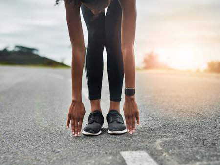 Stretch it out. an unrecognizable young sportswoman warming up for a workout outdoors.
