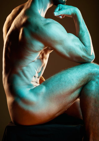 Body, art and strong with a nude man in studio on a dark background for artistic expression or freedom. Creative, sexy and model with a naked male posing to promote artwork, sensuality or fitnessの写真素材