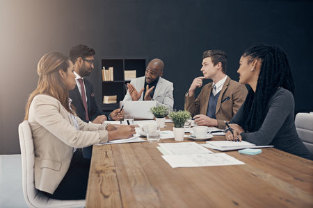 Lets take this to the next level. a group of Shot of a group of young businesspeople having a meeting in a modern office having meeting at work.の写真素材