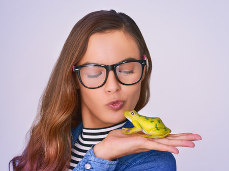All it takes is one kiss. Studio shot of a beautiful young woman posing against a purple background.の写真素材