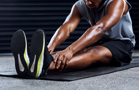 Always start with stretching. a sporty young man stretching his legs as part of his exercise...